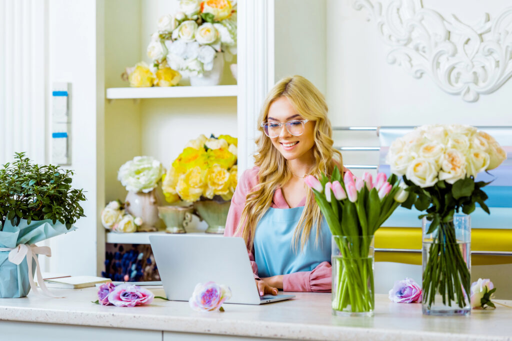 Blond Woman flower shop owner sitting at a desk